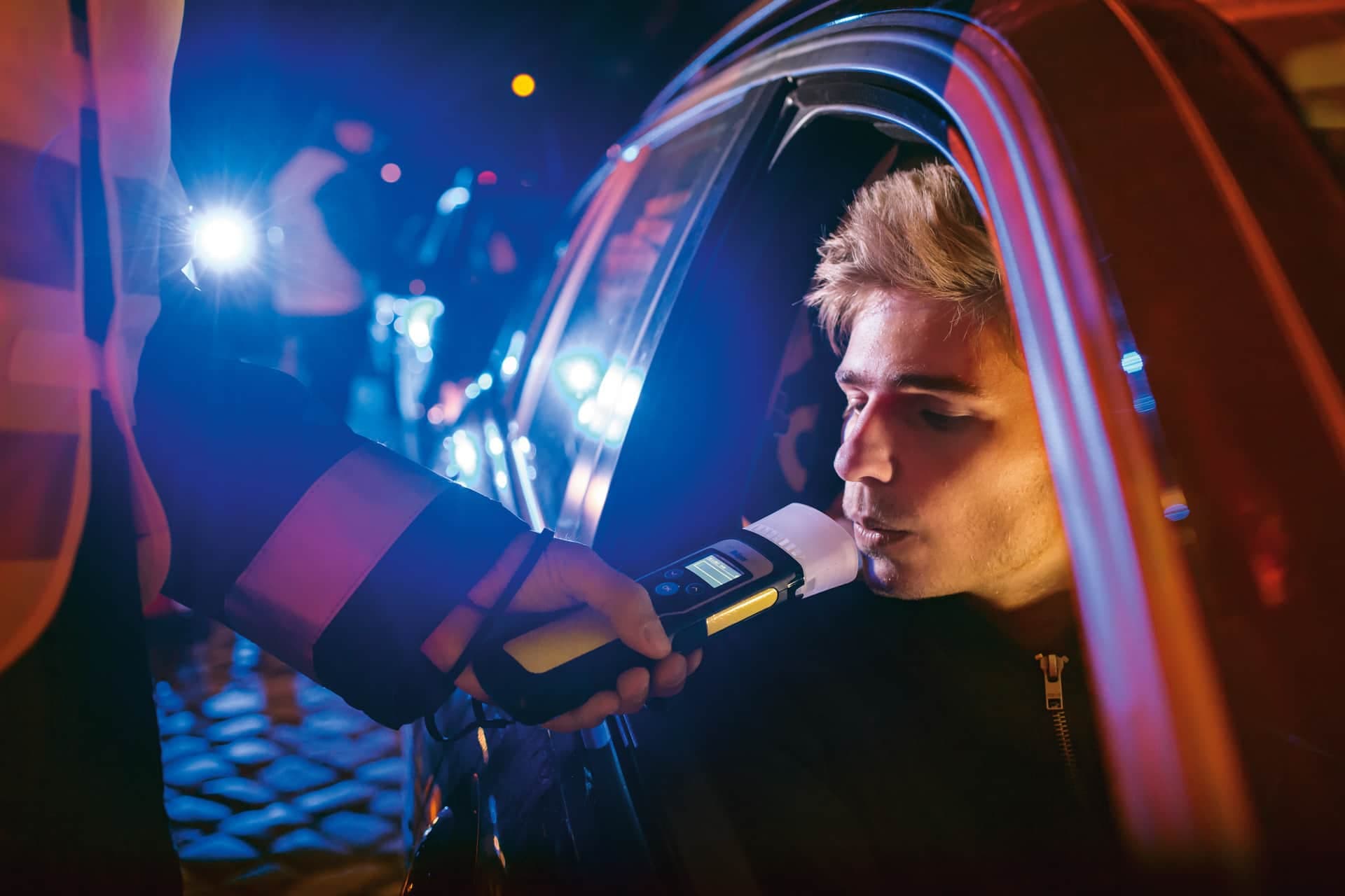 Policeman makes a quick non-contact alcohol breath test