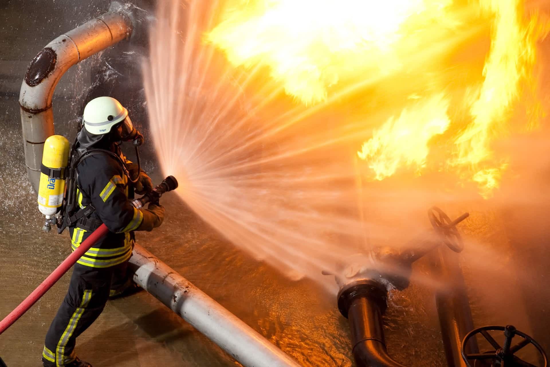 Firefighter extinguishes fire in an industrial plant using Dräger PSS 3000